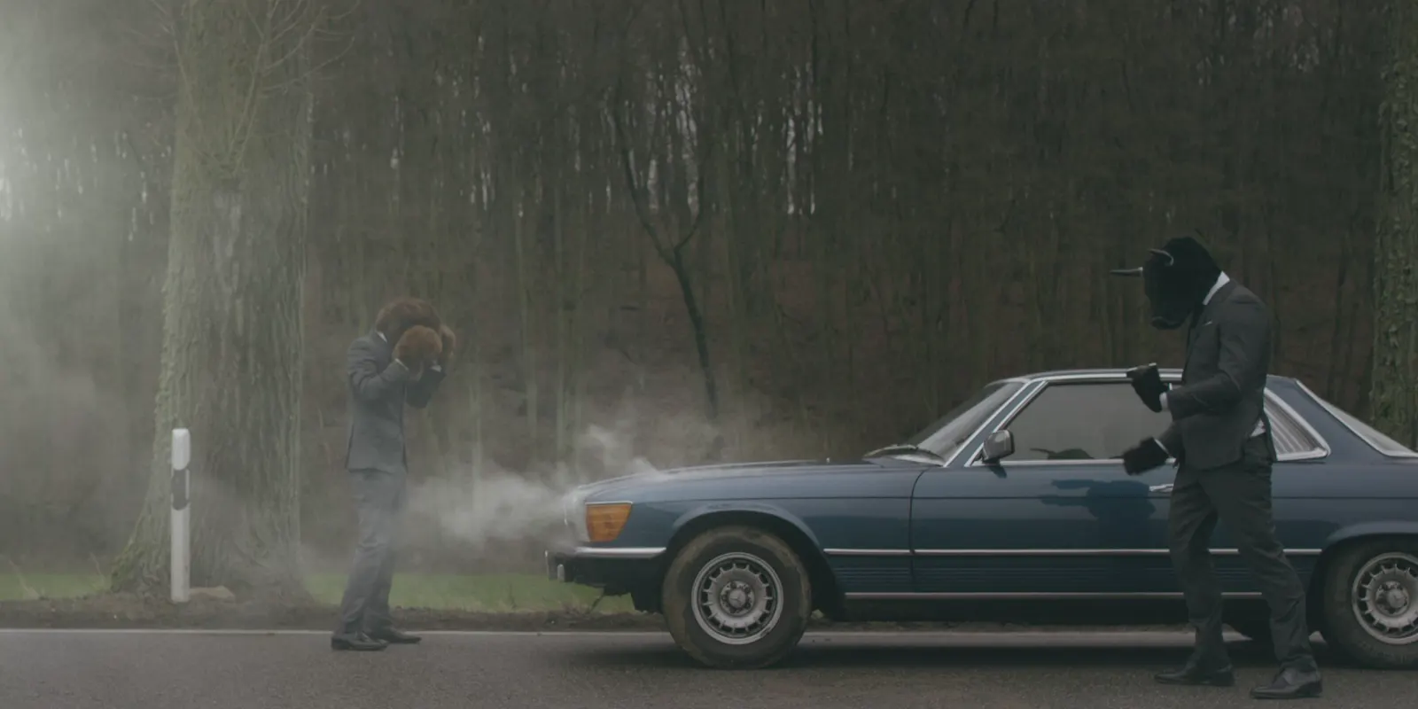 Bulle und Bär neben einem Oldtimer mit Motorschaden, Standbild aus dem TV-Spot