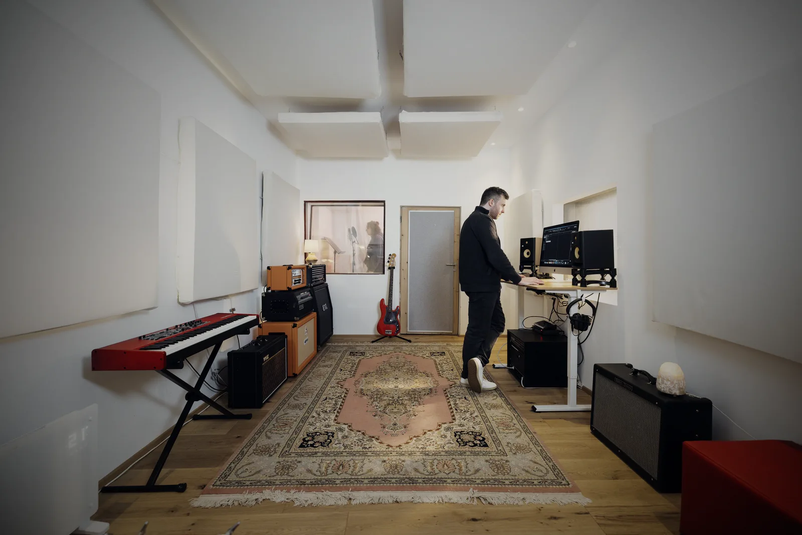 Aufnahmeraum mit Verstärkern und Keyboard, hinten die Gesangskabine